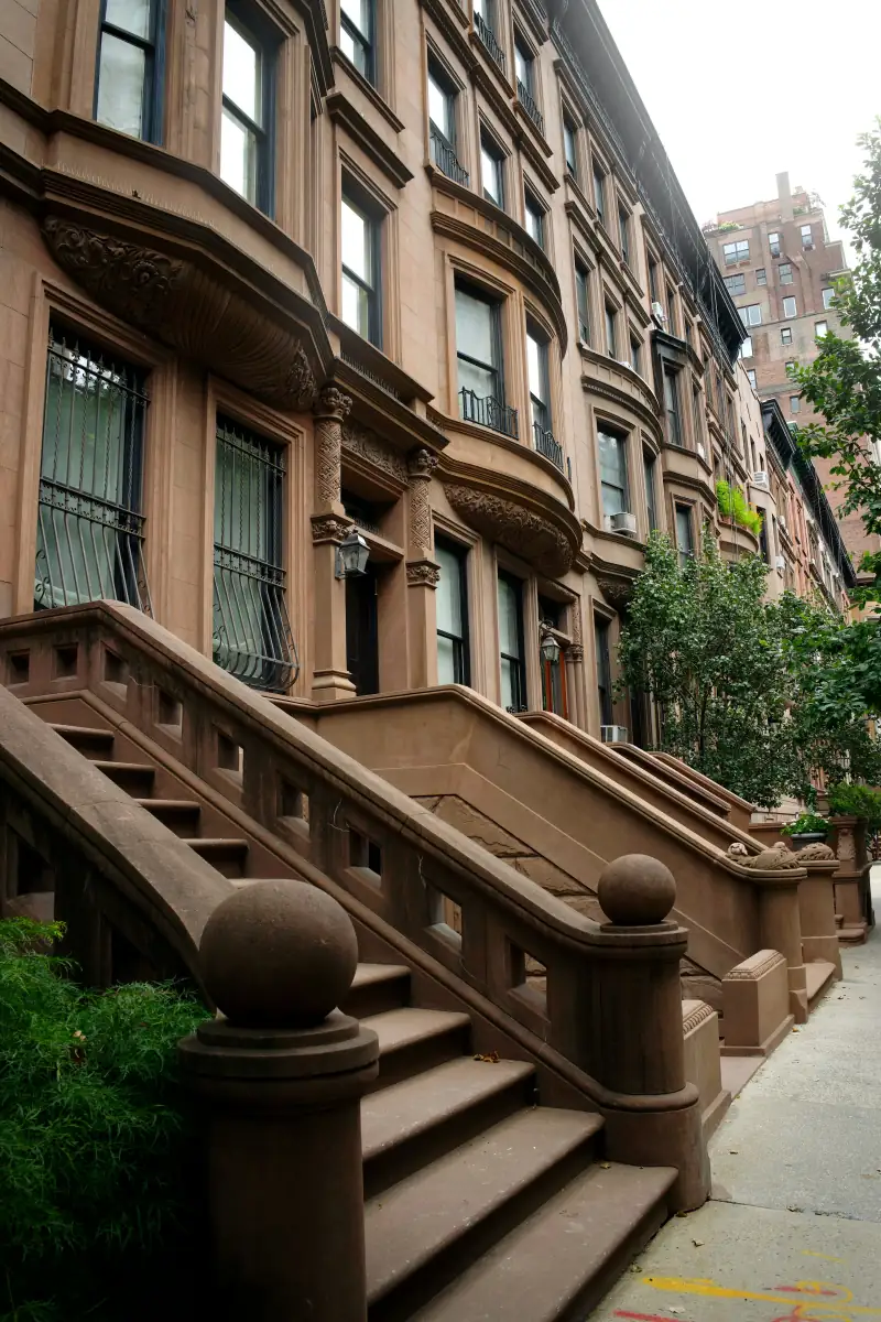 A row of UWS brownstones with ornate brown stone stoops